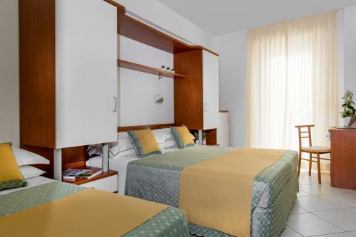カットーリカにあるHotel Principeのホテルルーム ベッド2台&椅子付