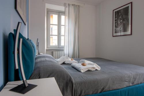a bedroom with a bed with two stuffed animals on it at MAJOR SISTERS, APPARTAMENTO VISTA LAGO DI LUGANO in Porto Ceresio