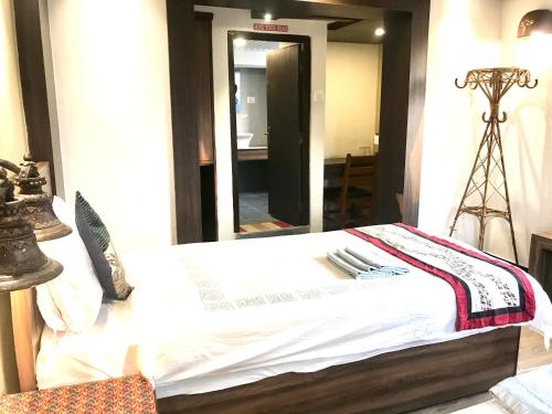 a bedroom with a bed with a table and a mirror at Shiva Guest House in Bhaktapur
