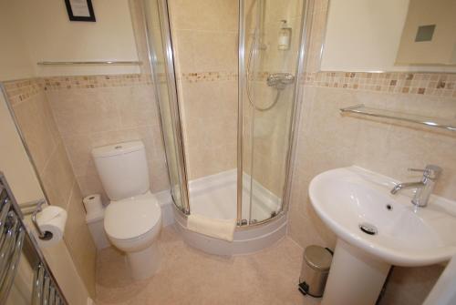 a bathroom with a toilet and a shower and a sink at Abbey Guest House York in York