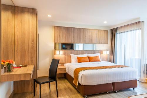 a hotel room with a bed and a desk at Pacific Park Hotel in Si Racha