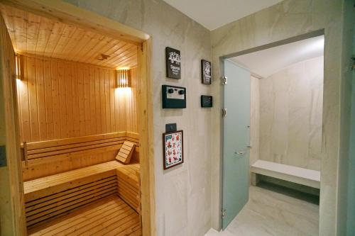 een badkamer met een sauna en een houten deur bij Pacific Park Hotel in Si Racha