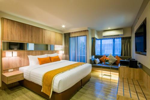 a hotel room with a bed and a living room at Pacific Park Hotel in Si Racha