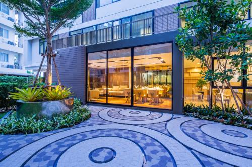 a building with a courtyard in front of it at Pacific Park Hotel in Si Racha