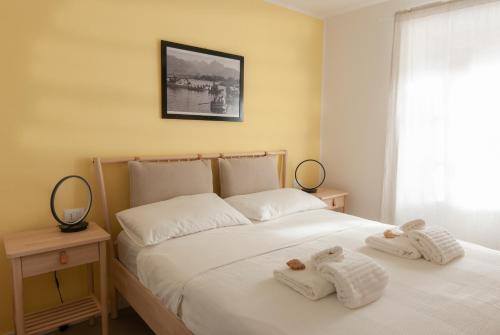 a bedroom with two white towels on a bed at MAJOR SISTERS, APPARTAMENTO VISTA LAGO DI LUGANO in Porto Ceresio