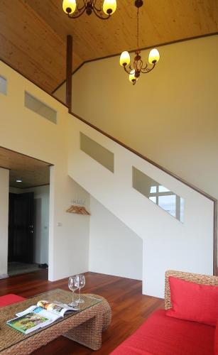 a living room with a staircase and a red couch at Jimei Homestay in Jian