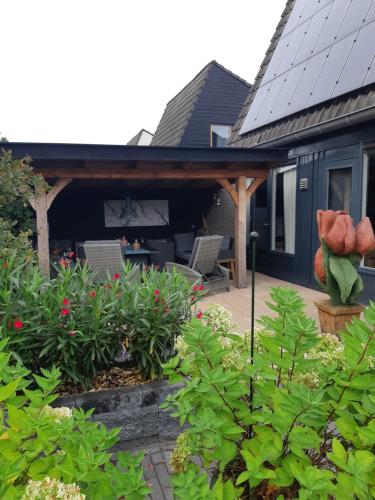 a house with a porch with chairs and plants at Weerribben Wieden gastenverblijf in Wanneperveen