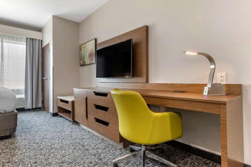 a hotel room with a desk and a yellow chair at Comfort Suites Greenville Airport in Greenville