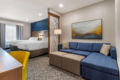 a hotel room with a couch and a bed at Comfort Suites Greenville Airport in Greenville