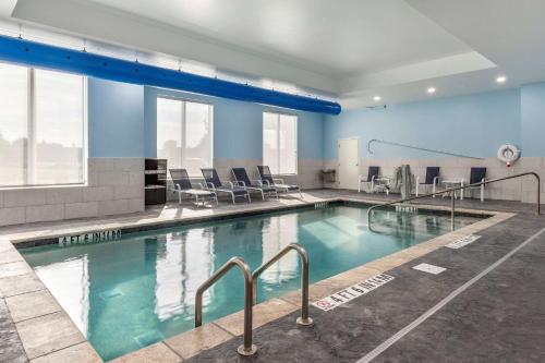 a large swimming pool with chairs in a building at Comfort Suites Greenville Airport in Greenville