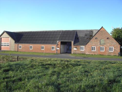 a large red brick building with a garage at Astrupgaard Farm Holiday in Skærbæk