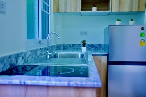 a kitchen with a sink and a refrigerator at The Nature House Aonang Krabi Thailand in Ao Nang Beach