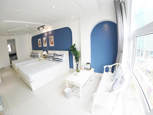 a bedroom with a white bed and blue walls at Dinh Phat Hotel in Ho Chi Minh City