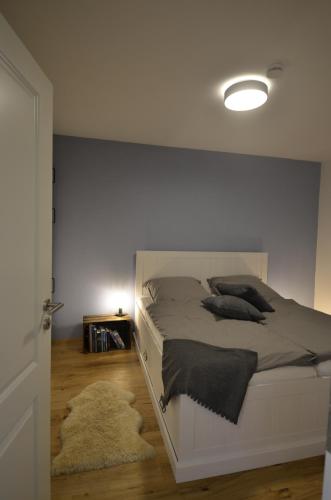 1 dormitorio con 1 cama con pared blanca en Bergnest Bad Bayersoien, en Bad Bayersoien