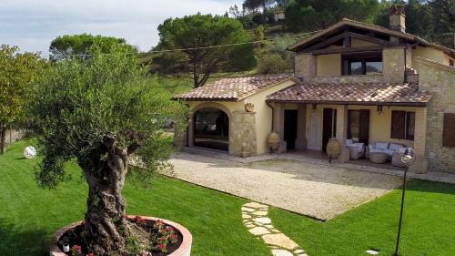 a house with a tree in a yard at GENIUS LOCI 6, Emma Villas in Collazzone