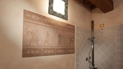 a bathroom with a shower with a painting on the wall at GENIUS LOCI 6, Emma Villas in Collazzone