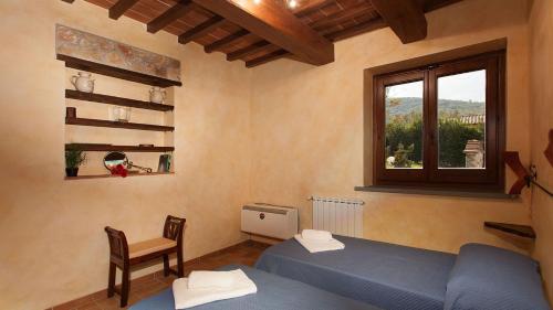 a room with a blue bed and a window at GENIUS LOCI 6, Emma Villas in Collazzone