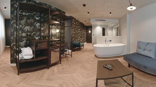 a living room with a bath tub and a couch at Hotel Sonne in Füssen