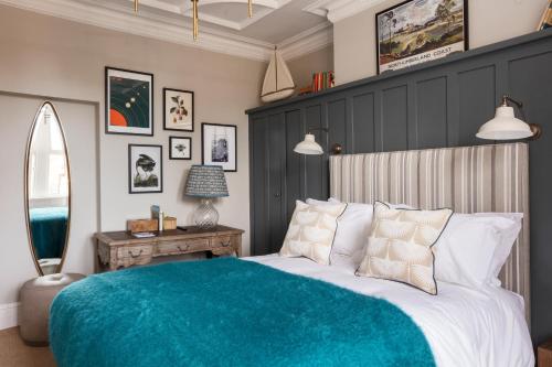 a bedroom with a large bed with a blue blanket at The Whittling House in Alnmouth