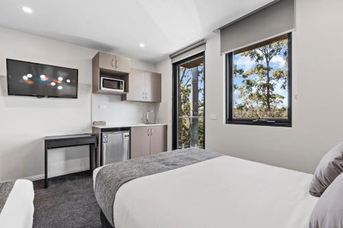 a hotel room with a bed and a window at Seranin | Gordon in Pymble