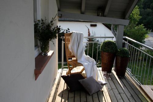 a wooden chair on a porch with a blanket on it at Landhaus Gräfendhron in Gräfendhron