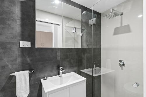 a white bathroom with a sink and a mirror at Seranin | Gordon in Pymble