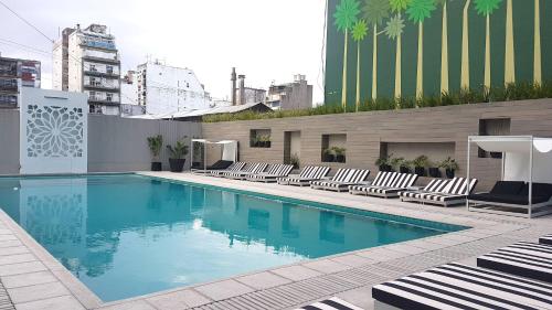 una gran piscina con tumbonas en un edificio en GrandView Hotel Buenos Aires en Buenos Aires