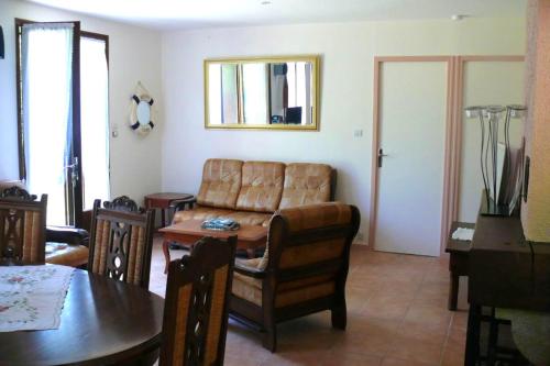 un salon avec un canapé et une table dans l'établissement Maison confortable sur jardin clôturé à Marcillac-la-Croisille, à Marcillac-la-Croisille