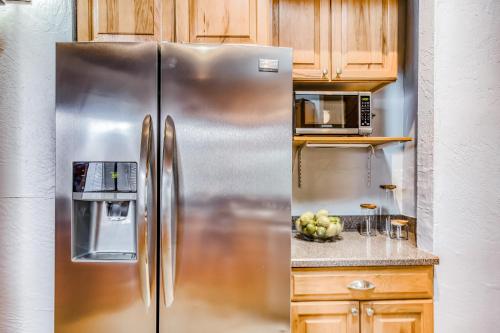 a stainless steel refrigerator in a kitchen with wooden cabinets at Kona Paradise in Kailua-Kona
