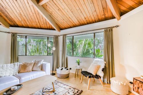 a living room with a white couch and some windows at Kona Paradise in Kailua-Kona