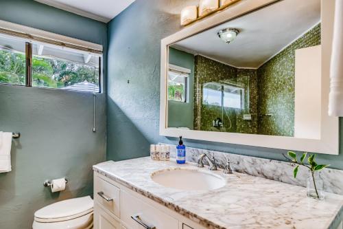 a bathroom with a sink and a mirror at Kona Paradise in Kailua-Kona