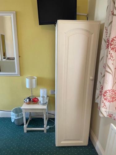 a room with a door and a table with a lamp at An Stór Townhouse in Midleton