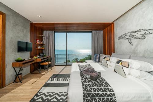 a bedroom with a bed and a desk and a television at The Cabin Beach Resort in Haad Rin