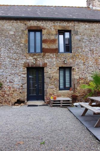 a stone house with a black door and windows at Maison charmante près de Sains avec spa et jardin clos in Sains