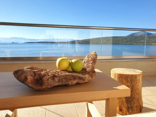 un tazón de manzanas en una mesa frente a una ventana en Boho Beach House in Itea-Delphi en Itea