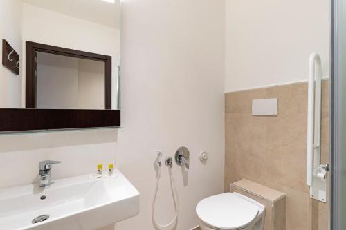 a bathroom with a toilet, sink, and shower at B&B Hotel Savona in Savona