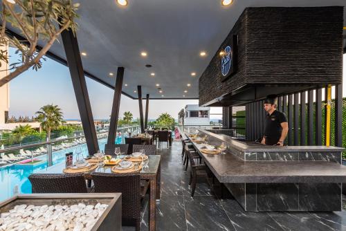 un uomo in piedi in un ristorante con tavoli e sedie di White City Resort Hotel - Ultra All Inclusive ad Avsallar