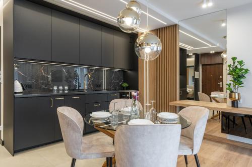 クラクフにあるGA Luxury Apartments G20のダイニングルーム(黒いキャビネット、テーブル、椅子付)