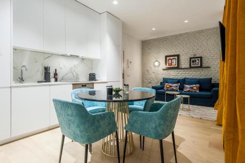 a kitchen and a living room with a table and chairs at Hauzify I Apartamento Salamanca in Madrid
