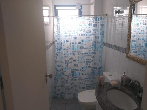 e bagno con lavandino, servizi igienici e doccia. di Rosana a Praia Grande