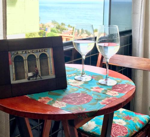 a table with two glasses of wine on a balcony at Porto Viejo Ô de Casa Natal RN in Natal