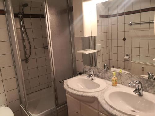 La salle de bains est pourvue de 2 lavabos et d'une douche. dans l'établissement Das Landhaus am Haff LHH A04, à Stolpe