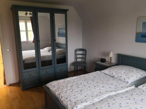 a bedroom with a bed and a dresser with a mirror at Das Landhaus am Haff LHH A04 in Stolpe