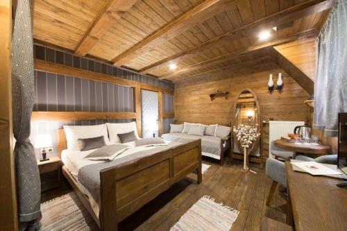a bedroom with a large bed and a couch at Ethno Houses Plitvice Lakes Hotel in Plitvica selo