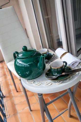 une table avec un pot vert et des tasses dessus dans l'établissement Flosoleil, à Beauvais