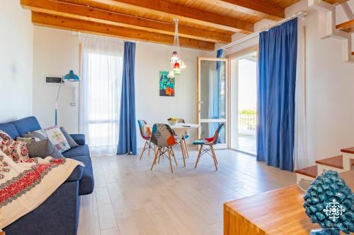 a living room with a blue couch and a table at Beach Front Villas in Calabernardo