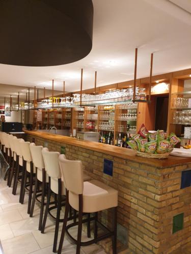 a bar with a row of stools in a restaurant at Studio 405 op zeedijk met frontaal zeezicht 4de verdiep in Middelkerke