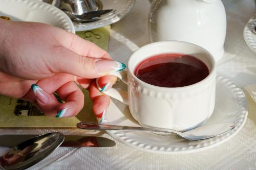a person holding a cup of coffee on a table at St Andrews Hotel in Exeter