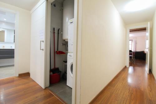 a kitchen with white walls and a wooden floor at Girona 108 in Barcelona