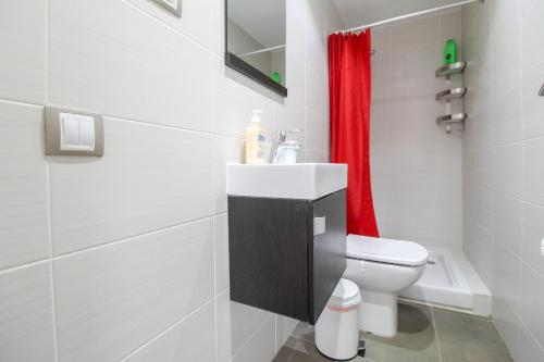 a bathroom with a toilet and a red shower curtain at Girona 108 in Barcelona